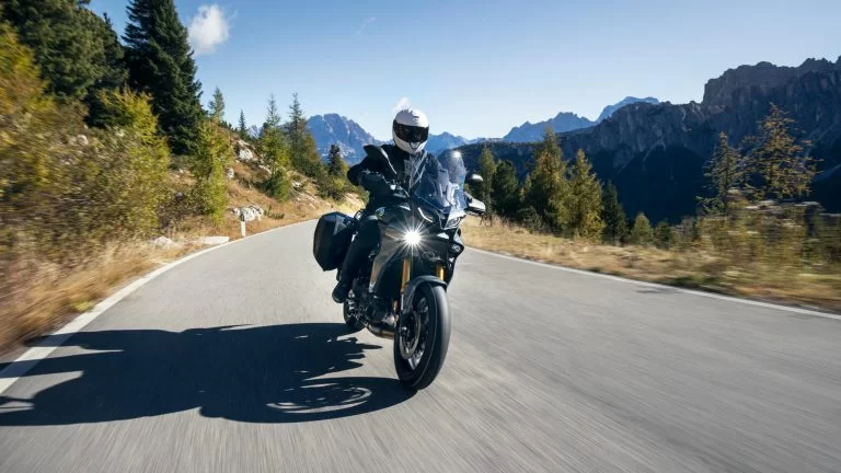 motorrijder met 2023 Yamaha tracer 9GT+ die over een bergpas rijdt.