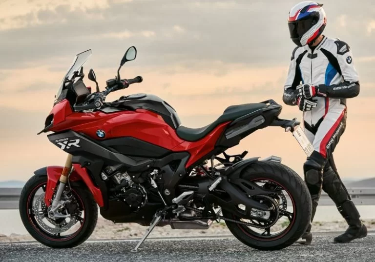 lifestyle foto van motorrijder die naar z'n 2023 bmw s1000xr toeloopt