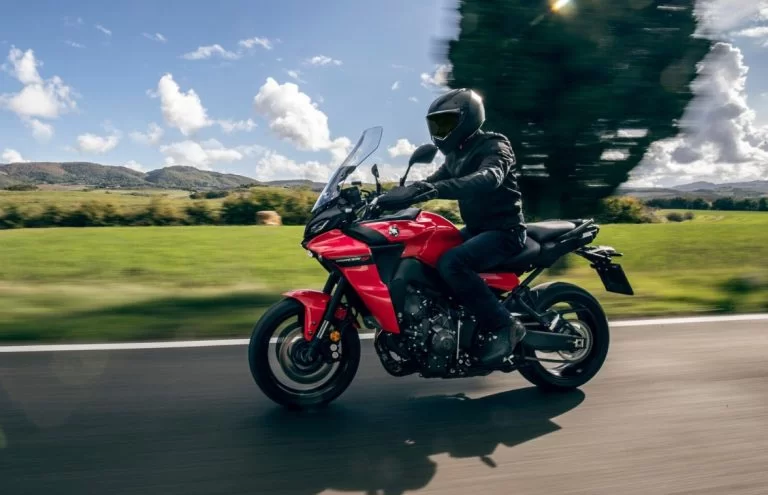 actiefoto van 2023 tracer9 van yamaha die door een glooiend landschap schiet