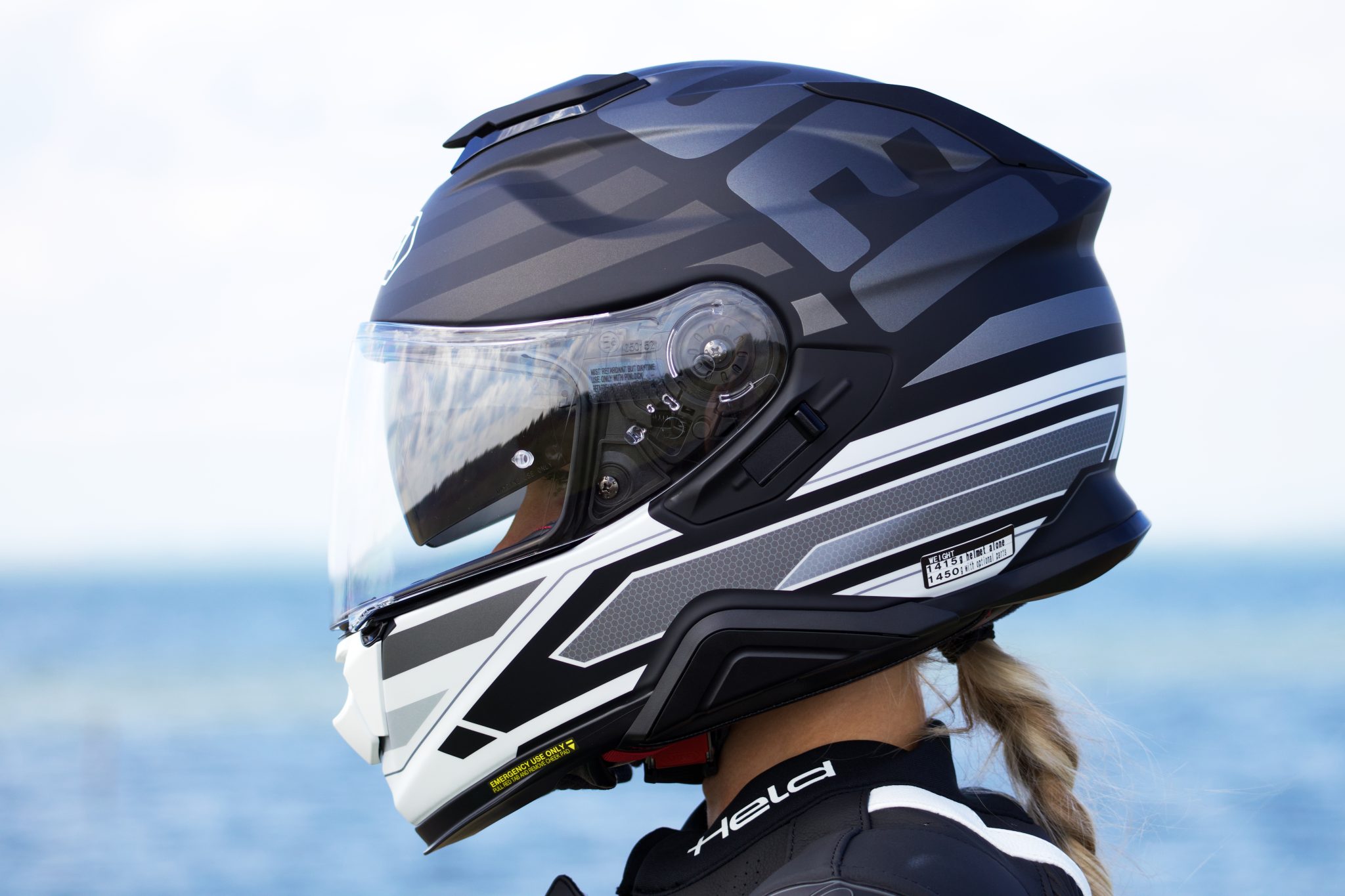 bikergirl dionne alojzija met een shoei motorhelm en de zee op de achtergrond