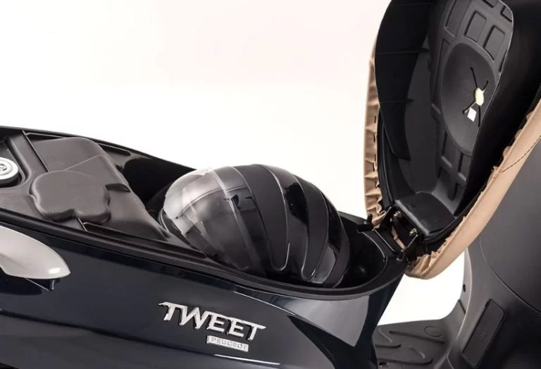 close up foto van de bergruimte van de peugeot tweet evo motorscooter waar makkelijk een helm in past.