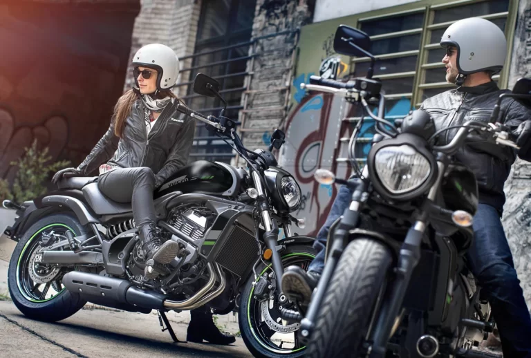 Lifestylefoto twee 2023 Kawasaki's Vulcan S met motorrijders met een graffiti muur op achtergrond