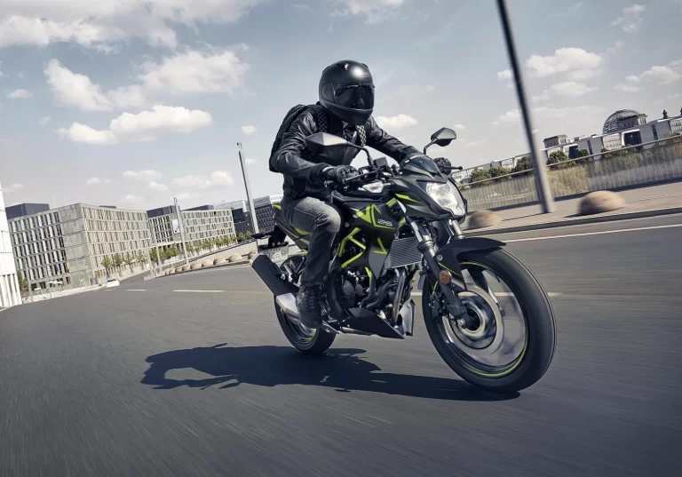 Actiefoto 2023 Kawasaki Z125 vooraanzicht met motorrijder in stedelijk gebied