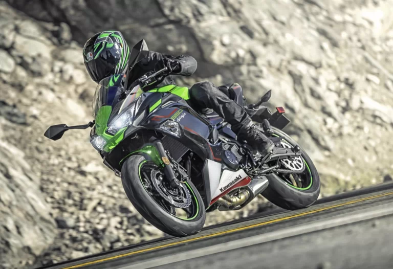 Actiefoto 2023 Kawasaki Ninja 650 van motorrijder die op een bergpas rijdt.