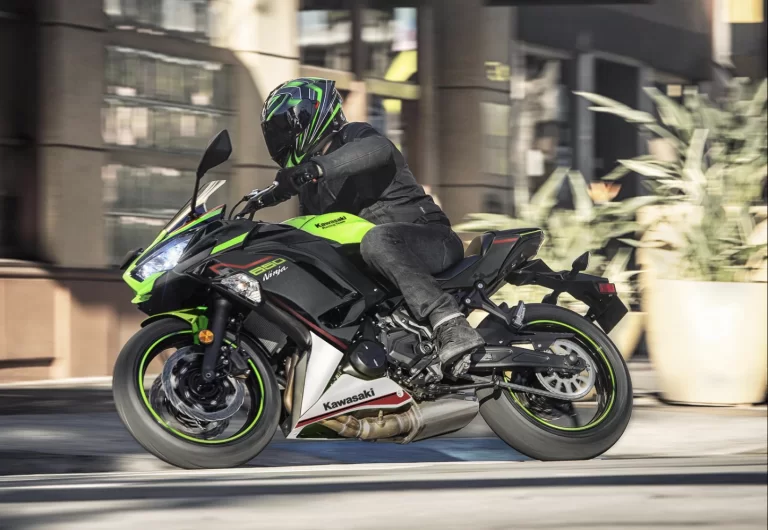 Actiefoto 2023 Kawasaki Ninja 650 die hangend een bocht in stedelijk gebied.