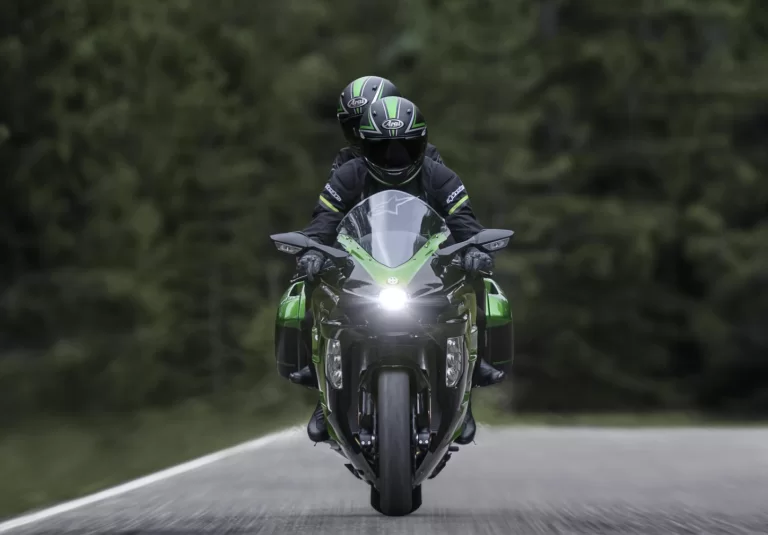 Actiefoto Ninja H2 SX vooraanzicht met motorrijder en passagier die recht in de camera kijken
