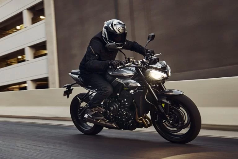 motorrijder die met hoge snelheid door de stad rijdt met een triumph street triple r