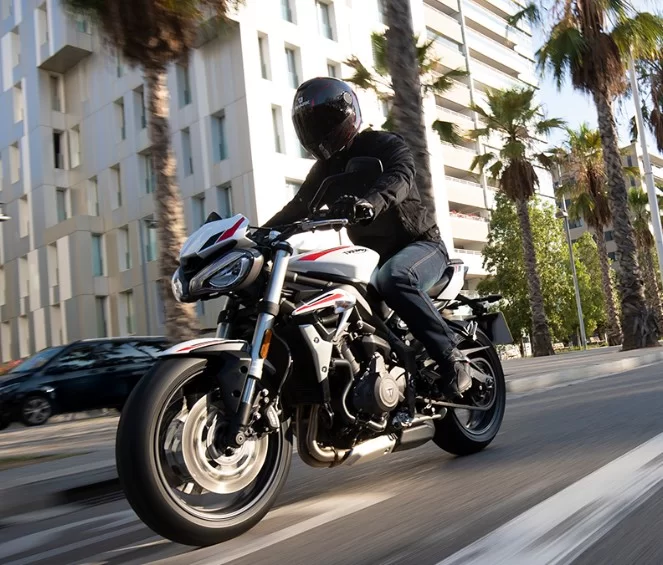 motorrijder op een triumph street triple s die door de stad rijdt