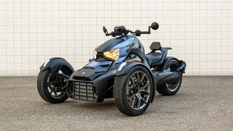 drie wieler staat voor een witte muur met de lampen aan