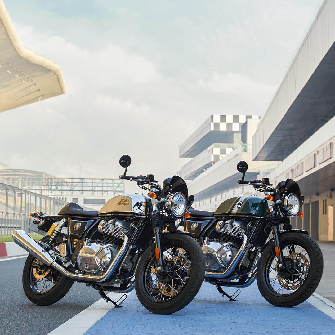 Twee Royal Enfield Continental GT 650 met race circuit op de achtergrond