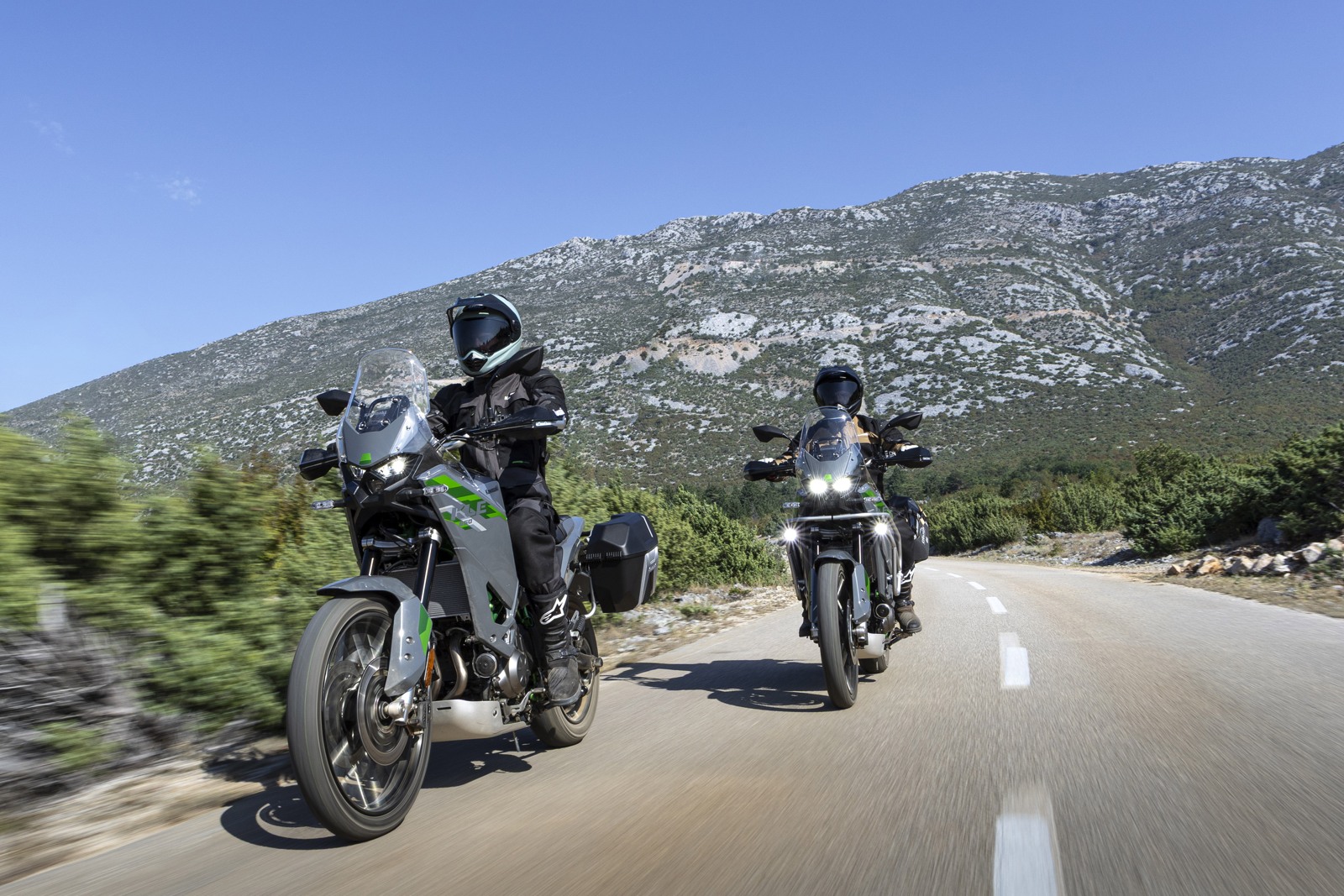 Twee Kawasaki KLE650 SE 2027 adventure-motoren op een bergweg