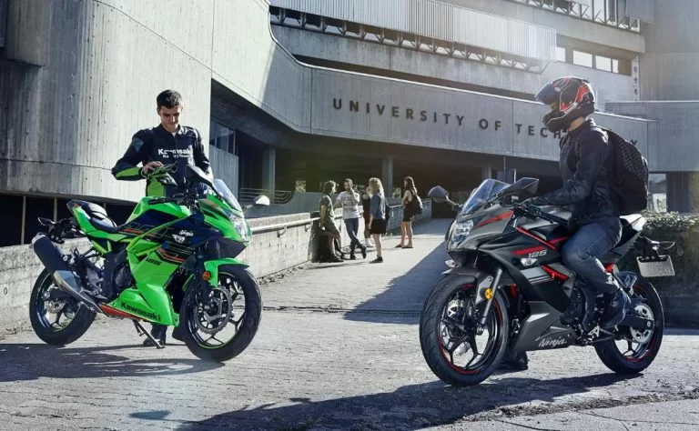 twee kawasaki mtoren met een gebouw op de achtergrond