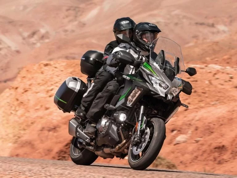 Kawasaki tourmotor met rijder en passagier in de bergen