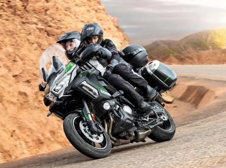 Kawasaki tourmotor in de bocht met bergen op de achtergrond