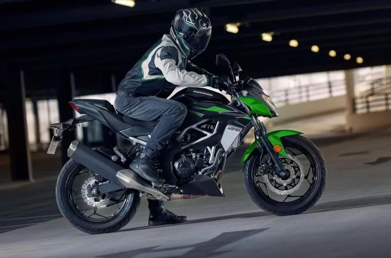 Kawasaki met rijder in parkeerplaats.