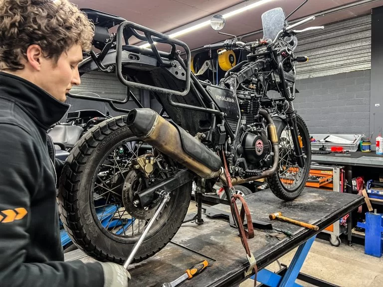 Monteur in werkplaats met motor band vervangen