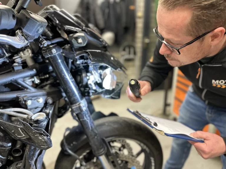 schadetaxateur aan het werk om schade aan motor te bepalen