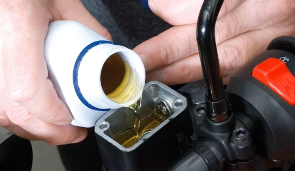 close up van iemand die remvloeistof van een motor bijvult