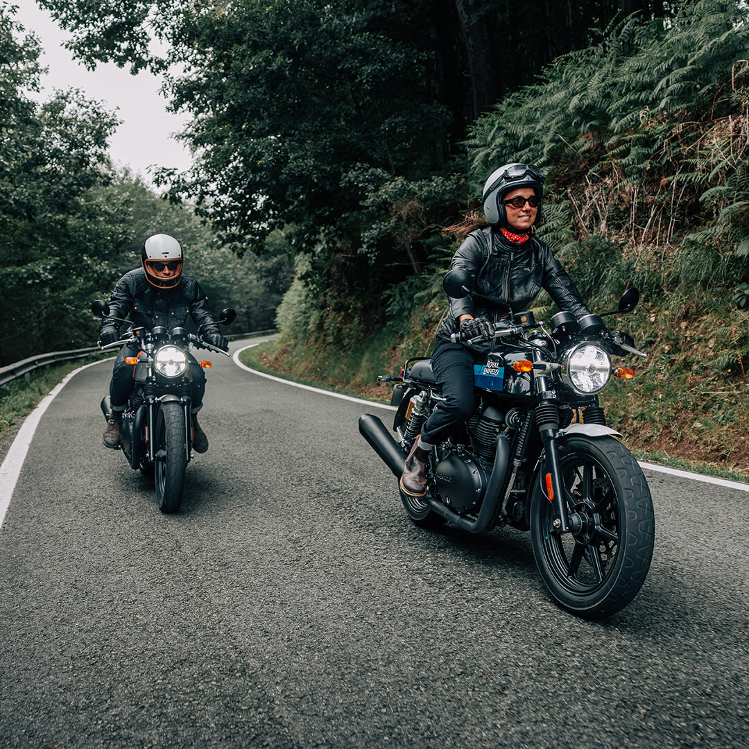 Twee Royal Enfield motoren rijdend over straat.
