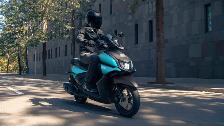 Yamaha motorscooter rijdend over straat.