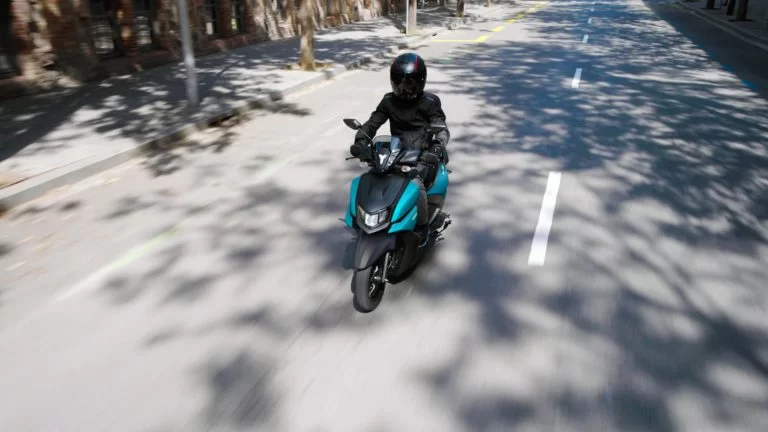 Yamaha motorscooter rijdend over straat.